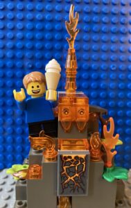 Child standing on volcano eating ice-cream in a cone.