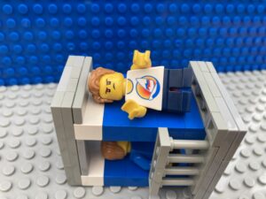 Child lying in bed with a cross face.