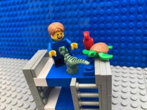 child playing with toys at the end of his bed