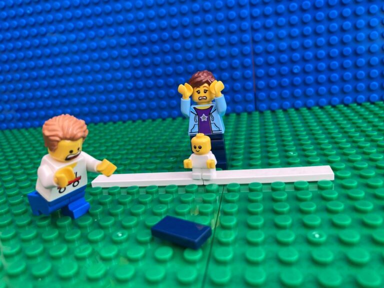 Child trying to reach the beanbag they have dropped in school sports day race