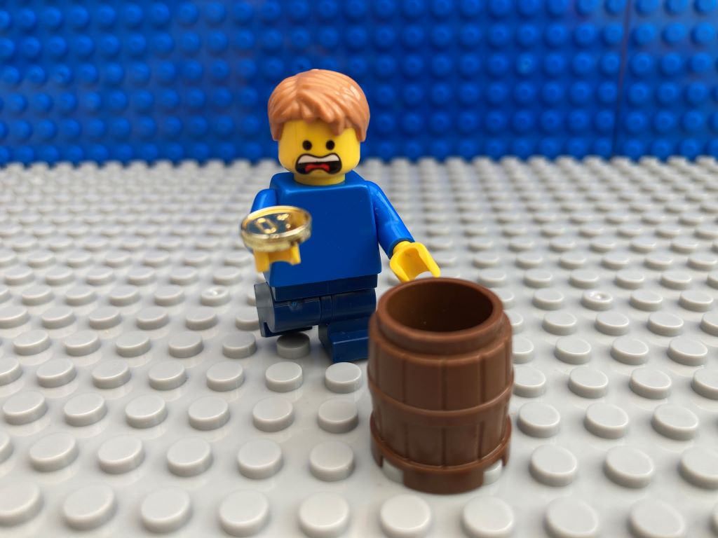Child looking worried as he looks as last coin in his pocket money barrel