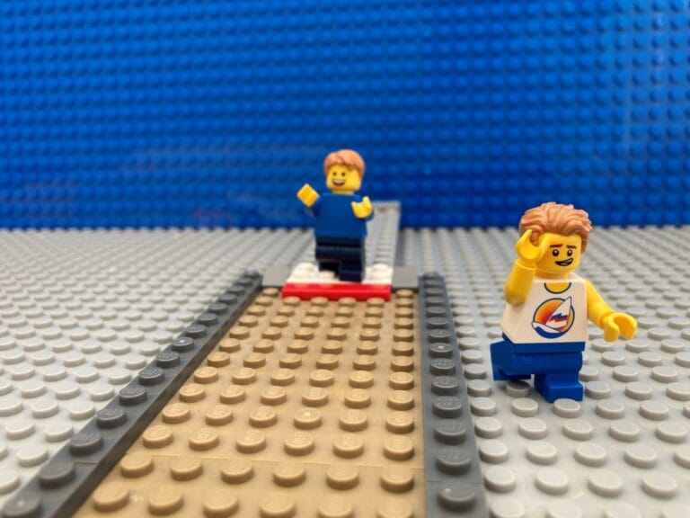 child running the long jump while older brother looks embarrassed at high school