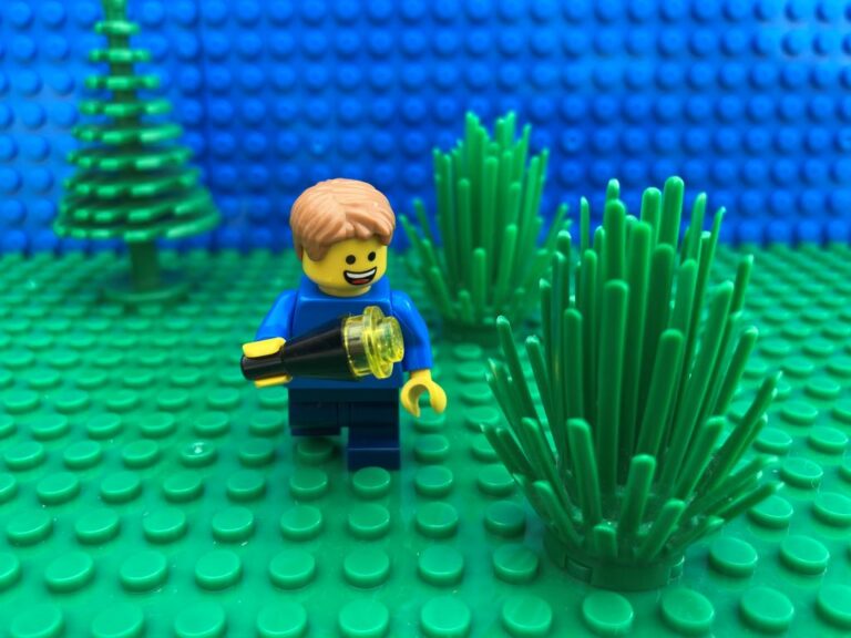 child peering into the bushes with a torch checking for monsters