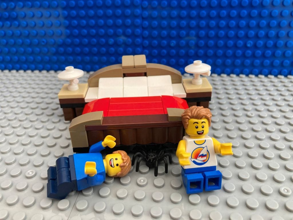 Children hiding the spider under the bed laughing
