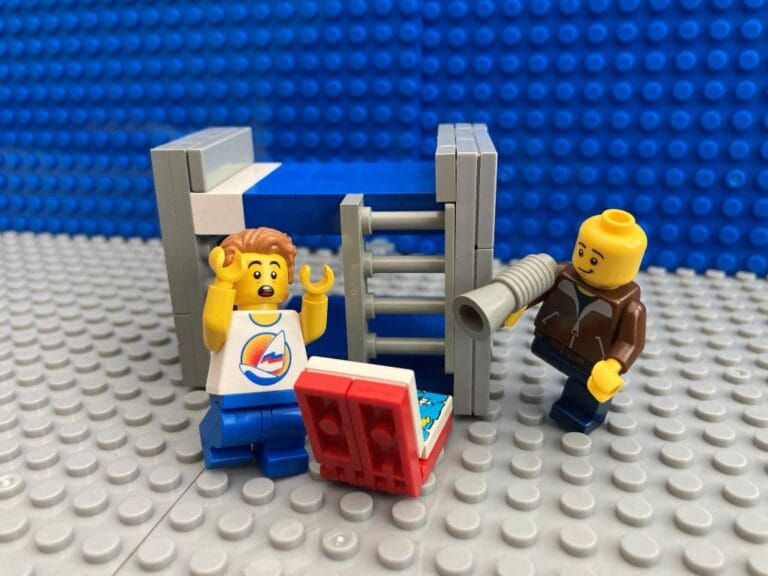 dad playing a playful prank and jumping out from behind bed and making child jump.
