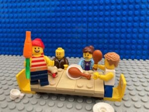 Parents help child to eat but child is dressed as a pirate and is walking the plank across the table