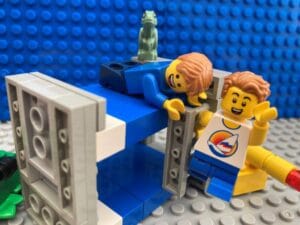 two children helping each other climb a ladder