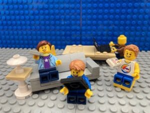 Whole family sitting down enjoying screen time on individual devices