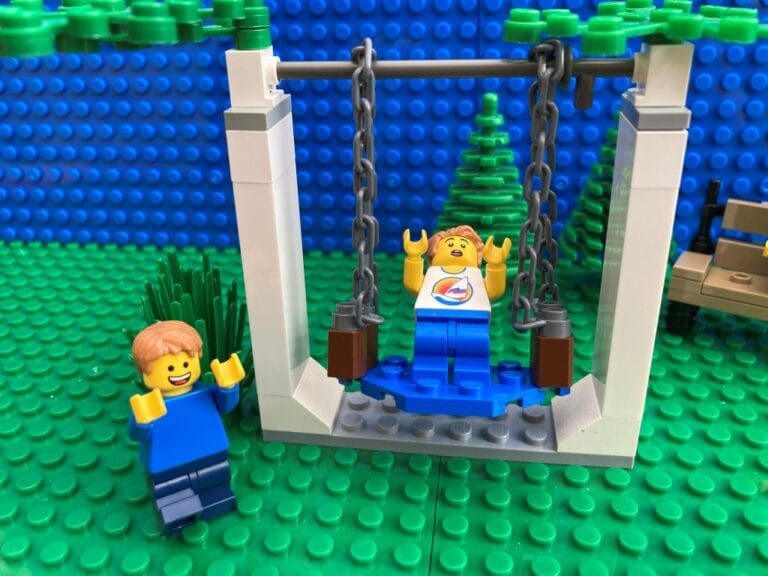 Child wobbling on the swing as he tries risk taking behaviour like not holding on to the ropes