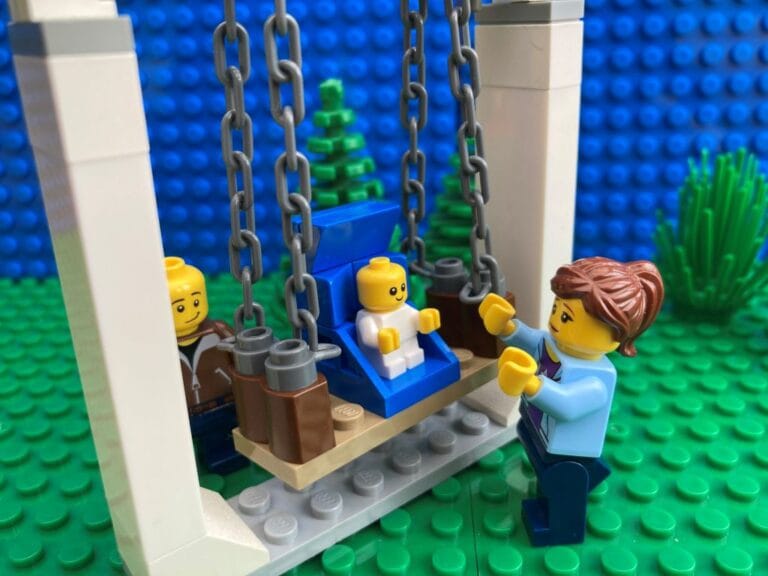 Mum and Dad pushing a small baby on a swing