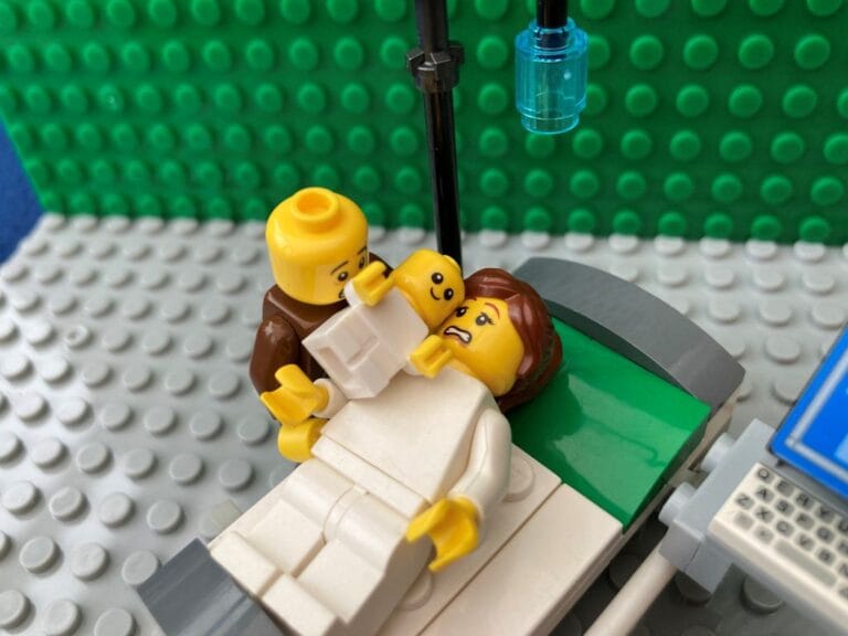 Mum and Dad in hospital theatre after an emergency c-section looking worried and scared