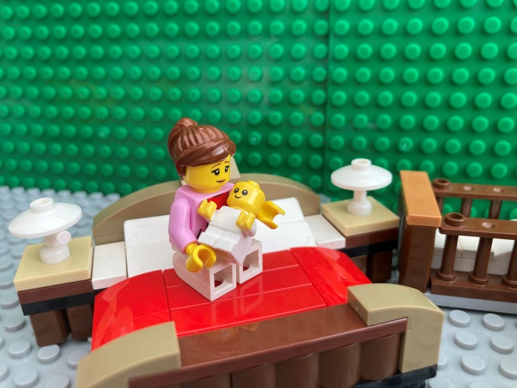 Mum cuddling baby on a bed as part of newborn bonding techniques