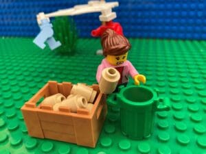 Mum rummaging through recycling bin looking for toilet roll tubes to make kid friendly bird feeders