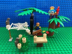 Two children hang out their kid friendly bird feeders and watch for birds in their garden