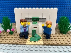 Mum looking horrified as lots of cash flies out of a cash machine. Young child looking thrilled