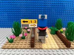 Smartphone character pointing happily to a signpost by the side of the road