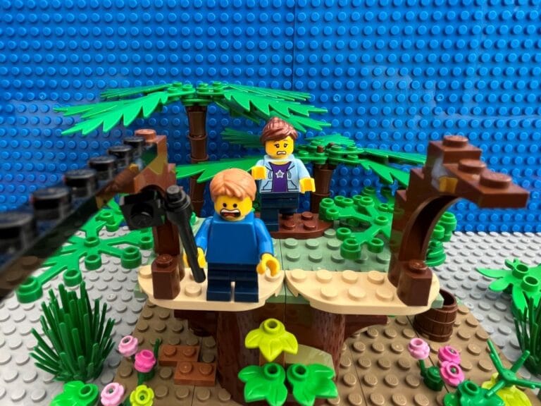 Mum holding a child back at the top of the platform before he jumps off on the zip-line