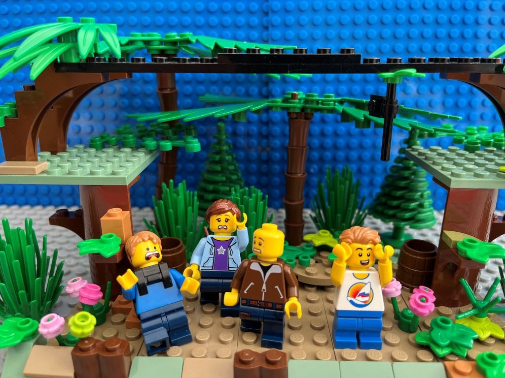 Family looking up scared at a high zip-line in the trees