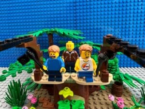 Two kids on the platform ready to jump off on the zip-line. One looks terrified while the other is excited