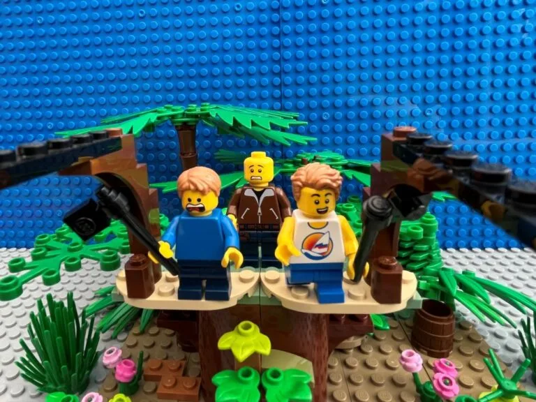 Two kids on the platform ready to jump off on the zip-line. One looks terrified while the other is excited