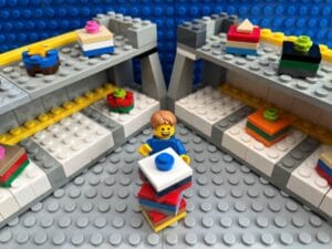 Child stacking toy boxes on top of one another at a toy store