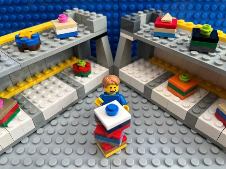 Child stacking toy boxes on top of one another at a toy store