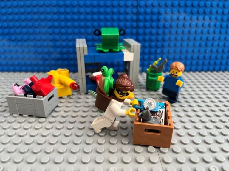 Mum dressed up in a black and white striped thief costume putting toys in a box