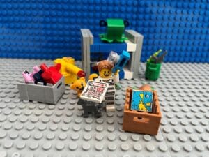Child dressed up in a black and white striped thief's costume taking stuff back out of the box