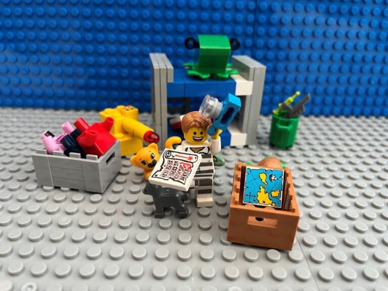 Child dressed up in a black and white striped thief's costume taking stuff back out of the box