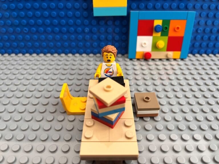 Child sitting at a table with lots of paperwork looking overhwelmed