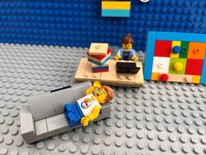 Mum doing child's homework while child rests on the sofa