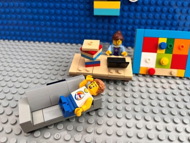 Mum doing child's homework while child rests on the sofa