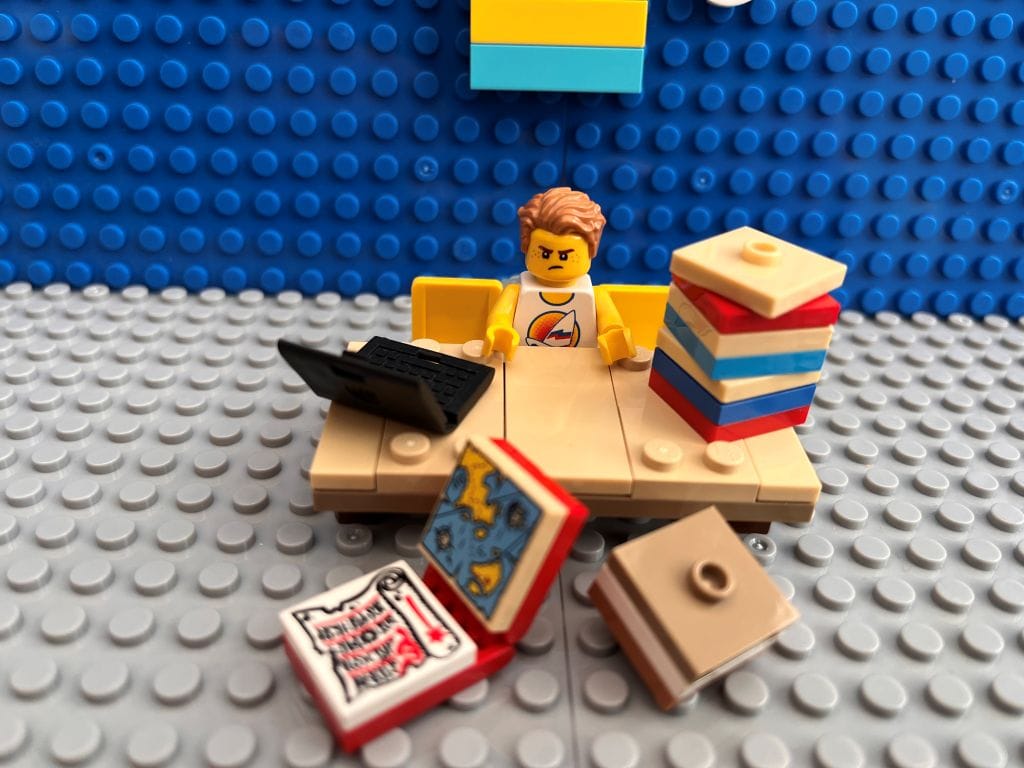 Child working through a mountain of homework at a table