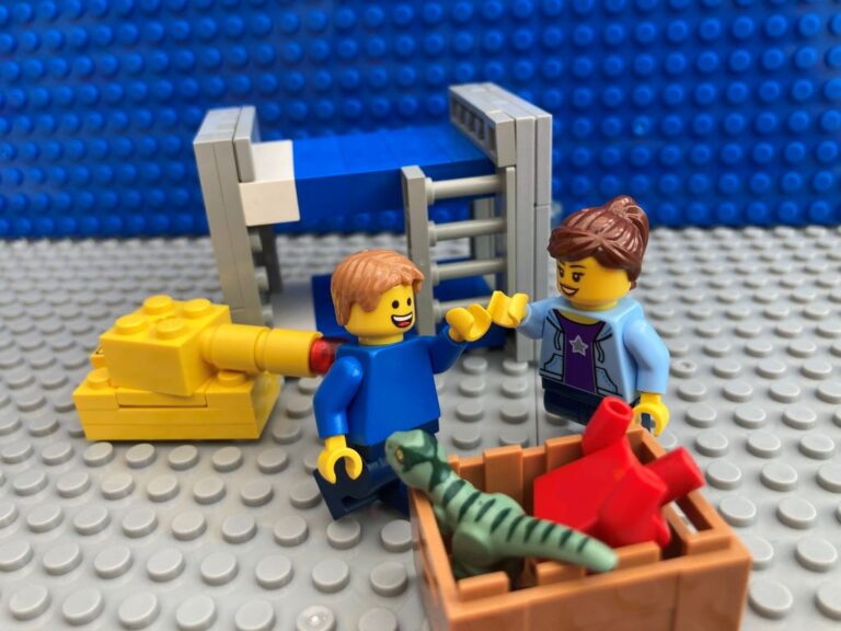 Mum and child high fiving after tidying up a box of toys