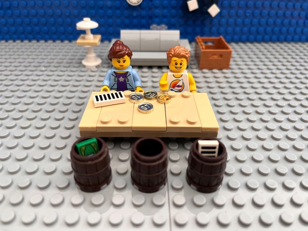 Mum and child sitting at a table with three pots learning budgeting